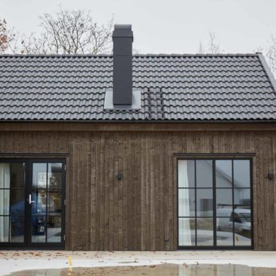 Arkitektritat hus med stora fönster och svarta detaljer
